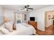 Comfortable bedroom with ceiling fan, wood floors, and access to the attached bathroom at 5120 Silabert Ave, Charlotte, NC 28205