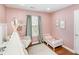 Pink bedroom with hardwood floors and a chair with a white tent at 5120 Silabert Ave, Charlotte, NC 28205