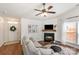 Cozy living room featuring a fireplace, modern ceiling fan, and natural light at 5120 Silabert Ave, Charlotte, NC 28205