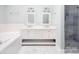 Elegant bathroom features a double vanity with modern fixtures, a soaking tub, and tiled walk-in shower at 7007 Chapparall Ln, Charlotte, NC 28215