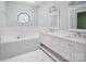 Bathroom featuring a large soaking tub and double vanity with a unique stained-glass window adding charm at 7007 Chapparall Ln, Charlotte, NC 28215