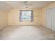 Bright bedroom features large window with natural light, a ceiling fan, and closet for a serene living space at 7007 Chapparall Ln, Charlotte, NC 28215