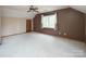 Bright bedroom features large window with natural light, a ceiling fan, and closet for a serene living space at 7007 Chapparall Ln, Charlotte, NC 28215