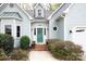Charming home showcasing a quaint entrance, complemented by lush landscaping and a welcoming front door at 7007 Chapparall Ln, Charlotte, NC 28215