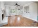 Bright living room features hardwood floors, a painted brick fireplace, large windows, and neutral decor at 7007 Chapparall Ln, Charlotte, NC 28215