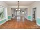 Bright living room with a fireplace, hardwood flooring, and large windows at 7007 Chapparall Ln, Charlotte, NC 28215