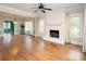 Inviting living room with hardwood floors, brick fireplace, and large windows bringing in plenty of natural light at 7007 Chapparall Ln, Charlotte, NC 28215