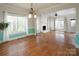 Spacious living room with hardwood floors, fireplace, and natural light from large windows at 7007 Chapparall Ln, Charlotte, NC 28215