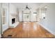 Bright living room features hardwood floors, a painted brick fireplace, large windows, and neutral decor at 7007 Chapparall Ln, Charlotte, NC 28215