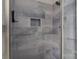Modern shower with gray tiled walls, a built-in niche, and glass door for a clean, contemporary design at 7007 Chapparall Ln, Charlotte, NC 28215