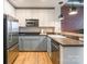 Modern kitchen features stainless appliances, two-tone cabinets and brick accent wall at 710 W Trade St # 314, Charlotte, NC 28202