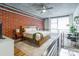 Comfortable loft style main bedroom with exposed brick, ceiling fan and railing overlooking the floor below at 710 W Trade St # 314, Charlotte, NC 28202