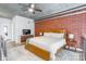 Spacious loft style main bedroom features an exposed brick wall and ceiling fan at 710 W Trade St # 314, Charlotte, NC 28202