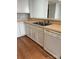 Functional kitchen features white cabinets, laminate counters, stainless steel sink, and a white dishwasher at 718 W Trade St # 302, Charlotte, NC 28202