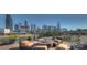 Stylish roof deck with city skyline views, featuring comfortable seating around a fire pit at 718 W Trade St # 302, Charlotte, NC 28202