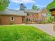 Expansive backyard featuring a brick patio, lush lawn, and mature landscaping for outdoor enjoyment and entertainment at 7329 Kennington Ct, Charlotte, NC 28270