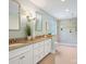 Bathroom featuring double vanity, decorative mirrors, tile floors, and a glass-enclosed shower at 7329 Kennington Ct, Charlotte, NC 28270