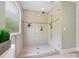 Modern glass enclosed shower featuring tile floors and walls, with natural light from a window at 7329 Kennington Ct, Charlotte, NC 28270