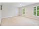 Spacious bedroom with bright windows overlooking greenery, plus neutral carpet and paint at 7329 Kennington Ct, Charlotte, NC 28270