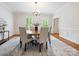 Elegant dining room features a modern chandelier, wainscoting, hardwood floors and neutral color palette at 7329 Kennington Ct, Charlotte, NC 28270