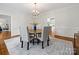 Bright dining room featuring a round table, six upholstered chairs, chandelier, and large area rug at 7329 Kennington Ct, Charlotte, NC 28270