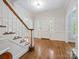 Bright foyer boasts hardwood floors, staircase with wooden banister, classic wainscoting and a front door with sidelights at 7329 Kennington Ct, Charlotte, NC 28270