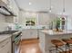 White kitchen boasts stainless steel range and subway tile backsplash overlooking a garden view at 7329 Kennington Ct, Charlotte, NC 28270