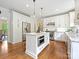 Bright kitchen features white cabinets, stainless steel appliances, marble countertops and hardwood floors at 7329 Kennington Ct, Charlotte, NC 28270