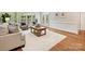 Bright living room with neutral sofa, area rug, hardwood floors, and shuttered windows at 7329 Kennington Ct, Charlotte, NC 28270