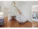 Traditional staircase featuring hardwood floors, white risers, wooden banister and trim, and an elegant, neutral carpet runner at 7329 Kennington Ct, Charlotte, NC 28270