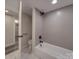 Modern bathroom with a gray subway tile surround, black fixtures, and a white marbled tile floor at 908 Davenport St, Charlotte, NC 28208