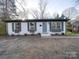 Charming single-story house with a white brick facade, a blue front door, and black shutters at 908 Davenport St, Charlotte, NC 28208