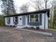 Charming single-story brick home featuring gray shutters, a cozy front entry, and mature trees at 908 Davenport St, Charlotte, NC 28208