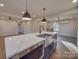 Large kitchen island featuring quartz countertop, undermount sink, and stainless steel appliances at 908 Davenport St, Charlotte, NC 28208