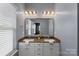 A bathroom with double sinks, granite counters, a framed mirror, and decorative lighting at 9330 Ainslie Downs St, Charlotte, NC 28273