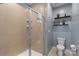 Bathroom featuring a glass shower with beige tiled walls and stylish decor on light blue walls at 9330 Ainslie Downs St, Charlotte, NC 28273