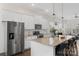 Modern kitchen featuring white cabinets, stainless steel appliances, and a large island with bar seating at 9330 Ainslie Downs St, Charlotte, NC 28273