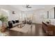 Bright living room with many windows features hardwood floors, modern furniture, and a ceiling fan at 9330 Ainslie Downs St, Charlotte, NC 28273