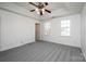 Bright bedroom featuring new carpet, a ceiling fan, and two windows providing natural light at 102 Brewster Ct, Mooresville, NC 28115