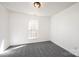 This bedroom features neutral paint, gray carpeting, and a window for lots of natural light at 102 Brewster Ct, Mooresville, NC 28115