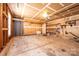 Unfinished garage featuring concrete floors, drywall walls, shelving, and a utility sink, offering ample storage and workspace at 102 Brewster Ct, Mooresville, NC 28115