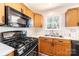 A well-lit kitchen features wooden cabinetry, laminate countertops, and modern black appliances at 102 Brewster Ct, Mooresville, NC 28115