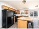 Kitchen view with dark appliances, wood cabinets, island with barstool seating and a sliding glass door to the yard at 102 Brewster Ct, Mooresville, NC 28115