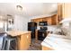 Kitchen featuring dark appliances, wood cabinets, marble counters, and an island with barstool seating at 102 Brewster Ct, Mooresville, NC 28115