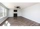 Well-lit living room with a fireplace, ceiling fan, and dark-colored laminate flooring at 102 Brewster Ct, Mooresville, NC 28115