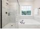 Bathroom features a soaking tub, a stand up shower and neutral marble-style tile at 149 Saidin Ln, Troutman, NC 28166