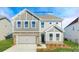 Two-story home featuring gray siding, a brick-lined garage, and a welcoming front porch with stone accents at 149 Saidin Ln, Troutman, NC 28166