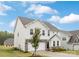 Side view of a two-story home with white siding, stone accents, an attached two-car garage, and a manicured lawn at 149 Saidin Ln, Troutman, NC 28166