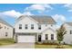 Charming two-story home with white siding, stone accents, a well-manicured lawn, and an attached two-car garage at 149 Saidin Ln, Troutman, NC 28166