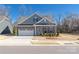 Charming brick home featuring a two-car garage, a light blue door, and beautifully landscaped front yard at 234 Pintail Dr, Monroe, NC 28110